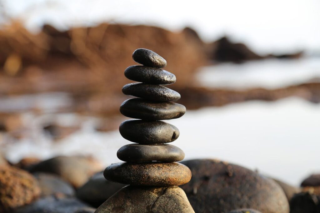 A balanced stack of smooth stones on a rocky shore