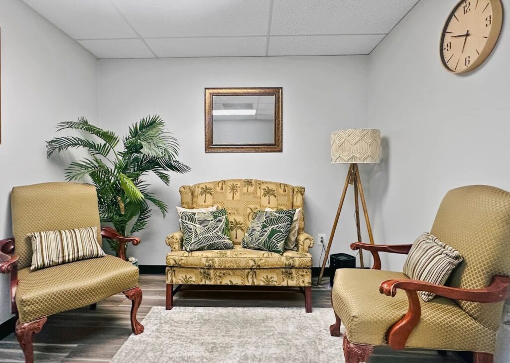 The Godaelli Woodbridge office waiting room with upholstered armchairs, a settee, and a wall clock